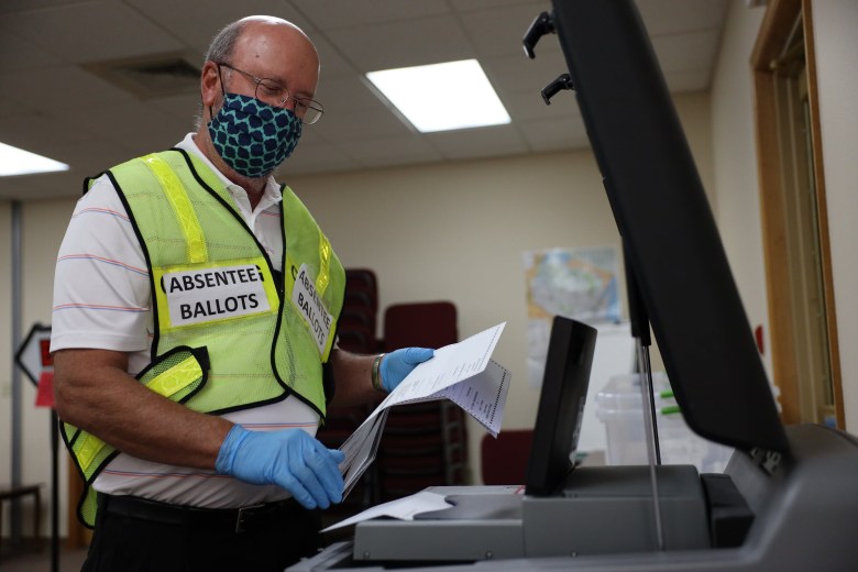 Volunteer Mike Otten processes absentee ballots that were received by mail at the municipal center in Rib Mountain, Wis., during the partisan primary on August 11, 2020.