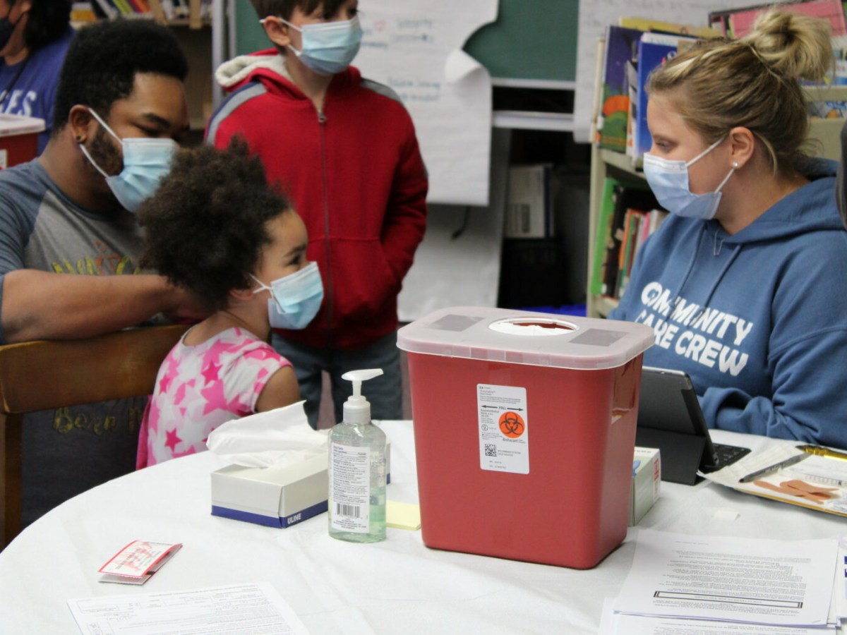 A young girl getting a shot at the clinic.