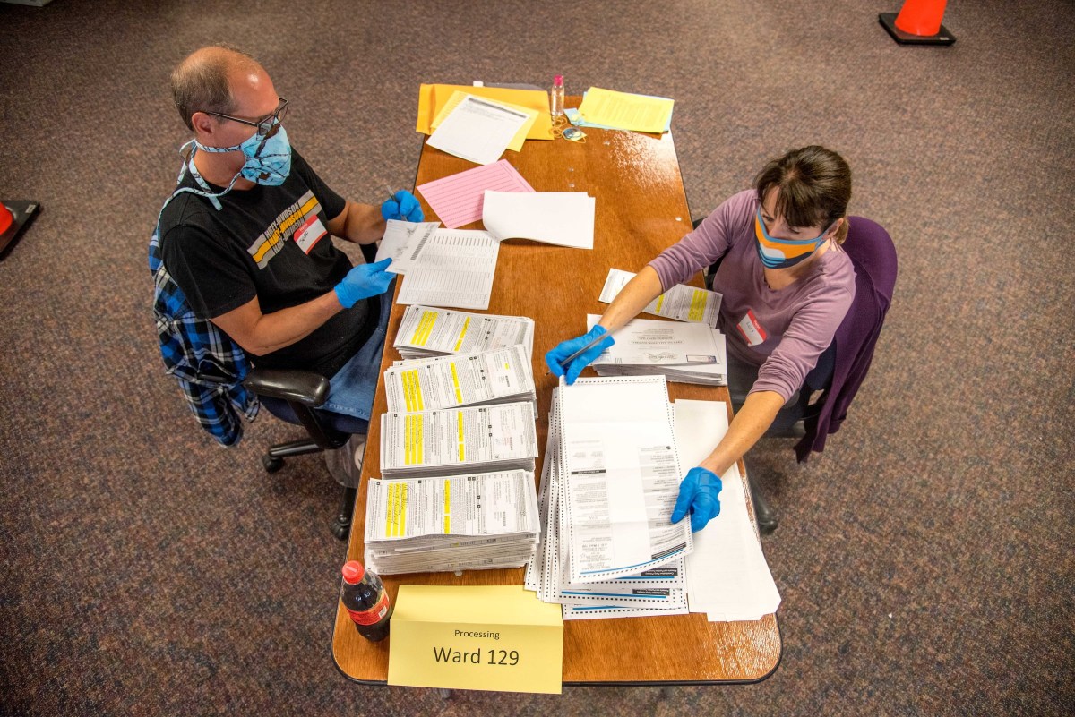 Election workers Jeff and Lori Lutzka process absentee ballots at Milwaukee's central count facility on Aug. 11, 2020.